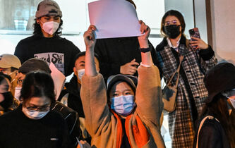 Une centaine de personnes posent avec des feuilles blanches, devenues un symbole de protestation contre la censure en Chine et contre la politique chinoise de “zéro Covid”